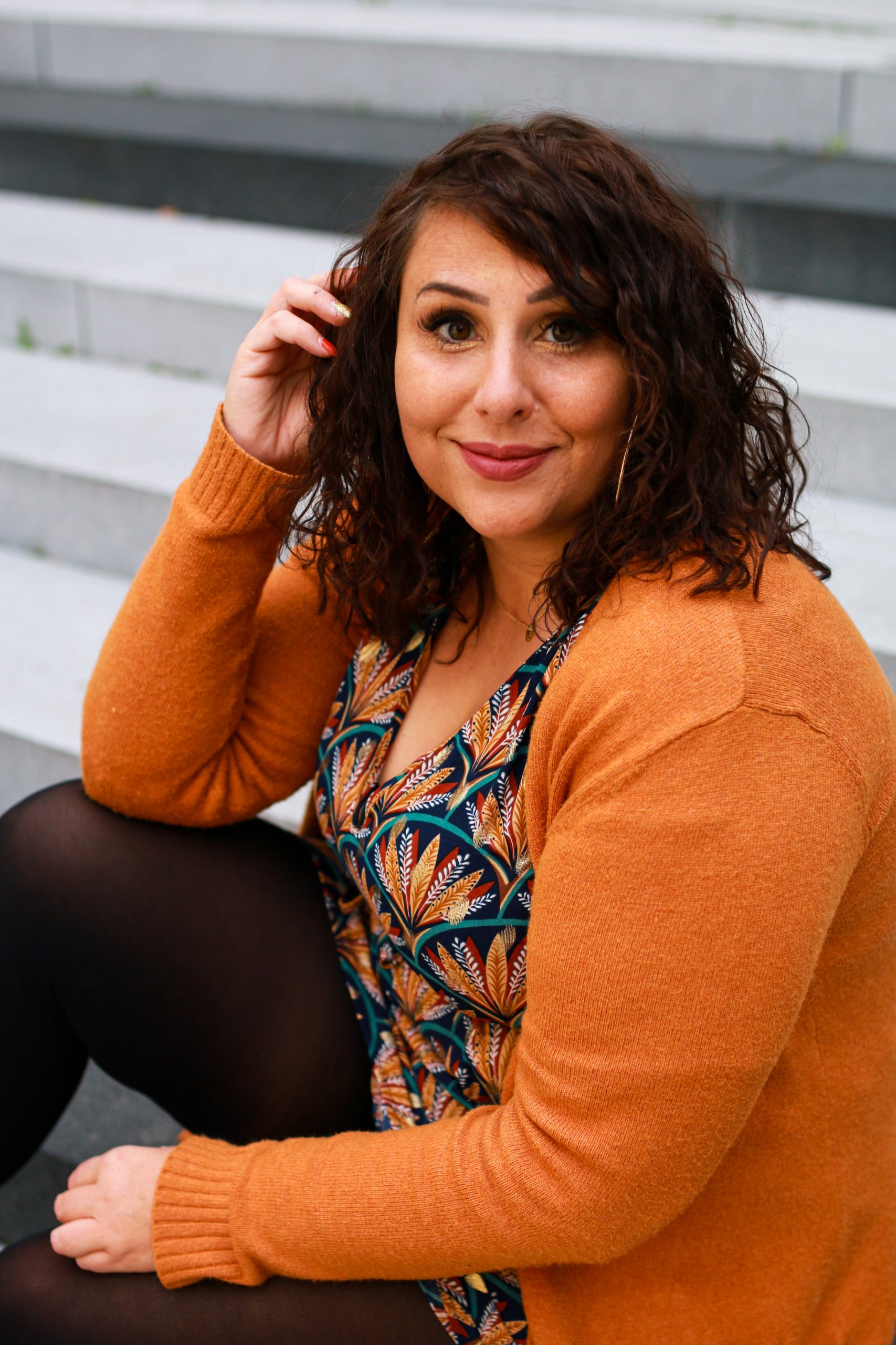 Mona Briese in orangenem Cardigan und blauem Kleid in Aachen
